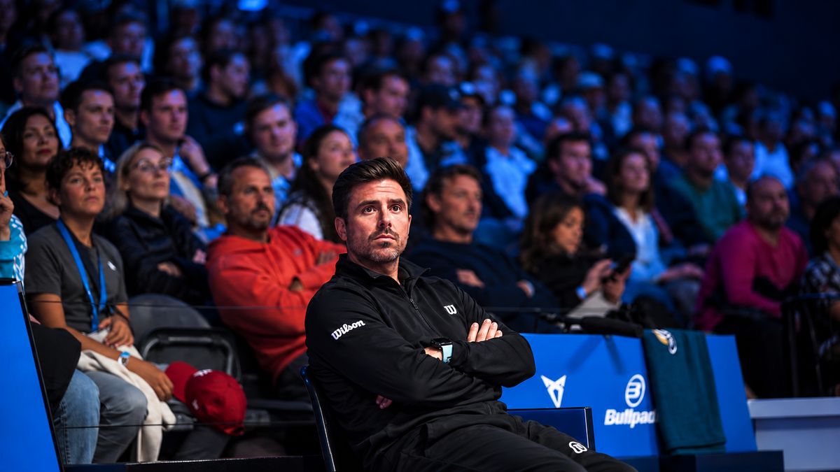 Un entrenador sigue un partido de pádel profesional desde el banquillo
